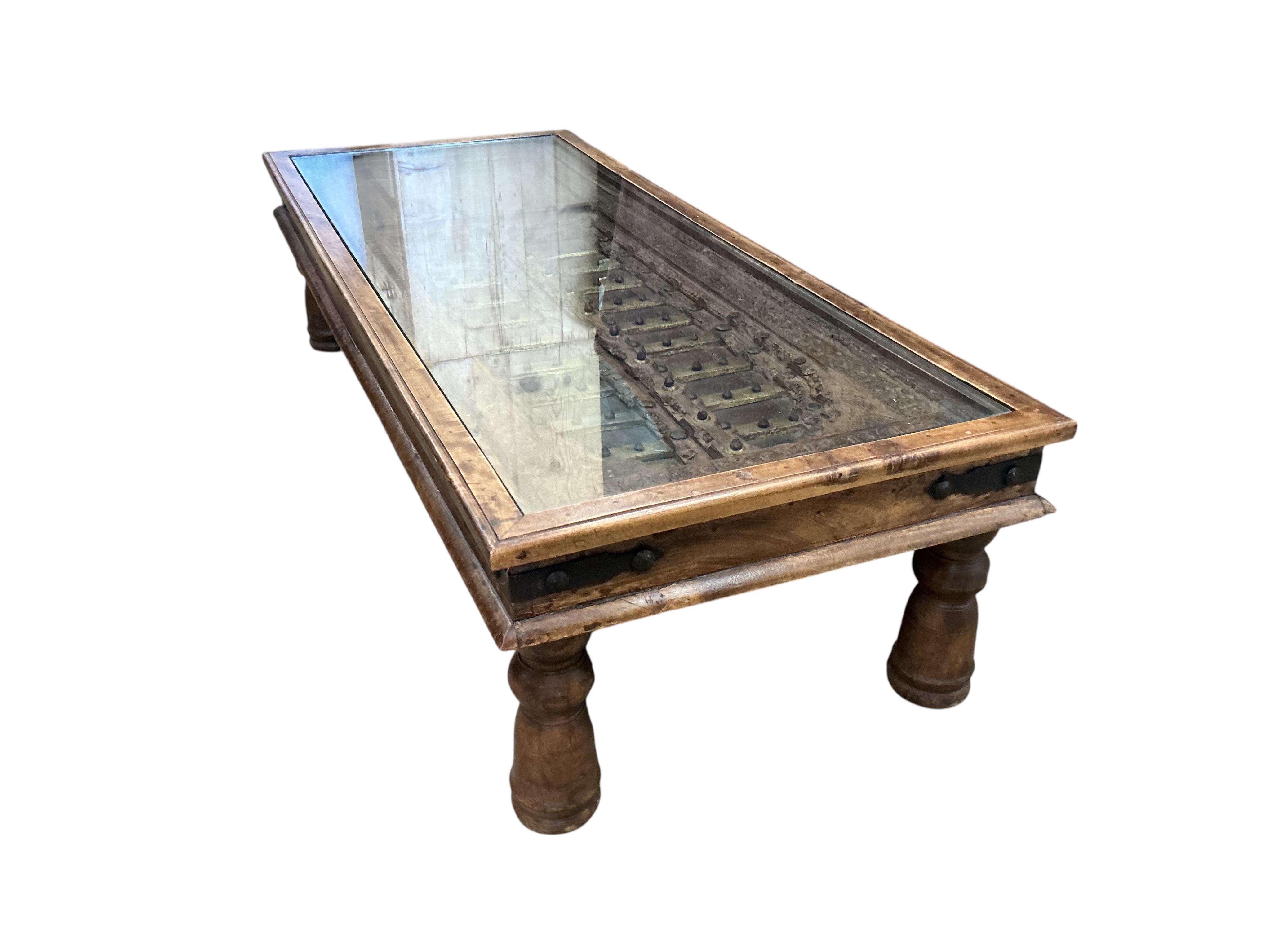 A 19th century brass mounted Indian door, now as a coffee table, width 154cm, depth 64cm, height 40cm